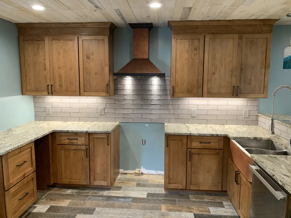 Kitchen with copper range hood on a lake house in Brighton, MI by Lux Builders